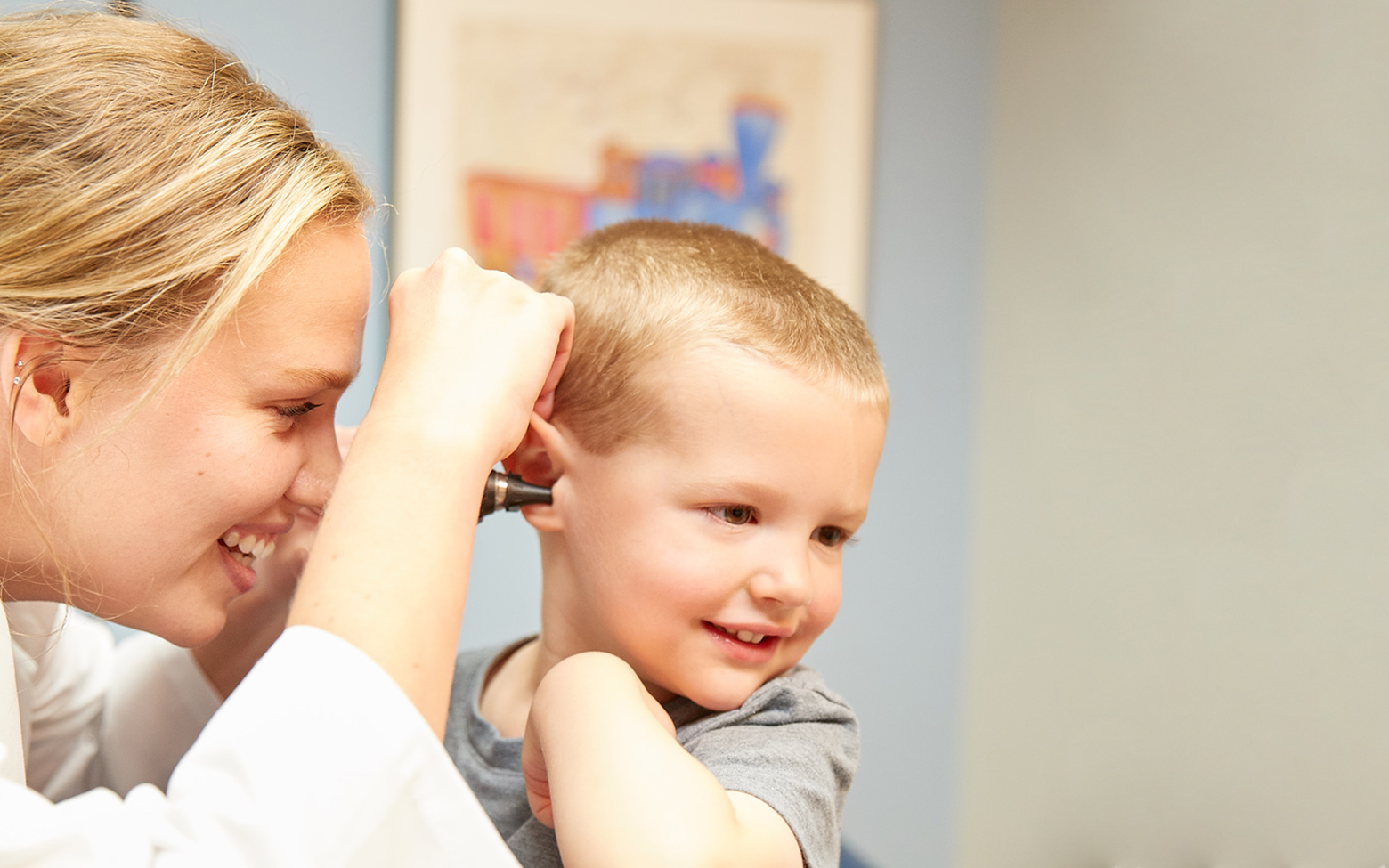 Doctor looking in the ear of a young patient in a QuadMed onsite clinic